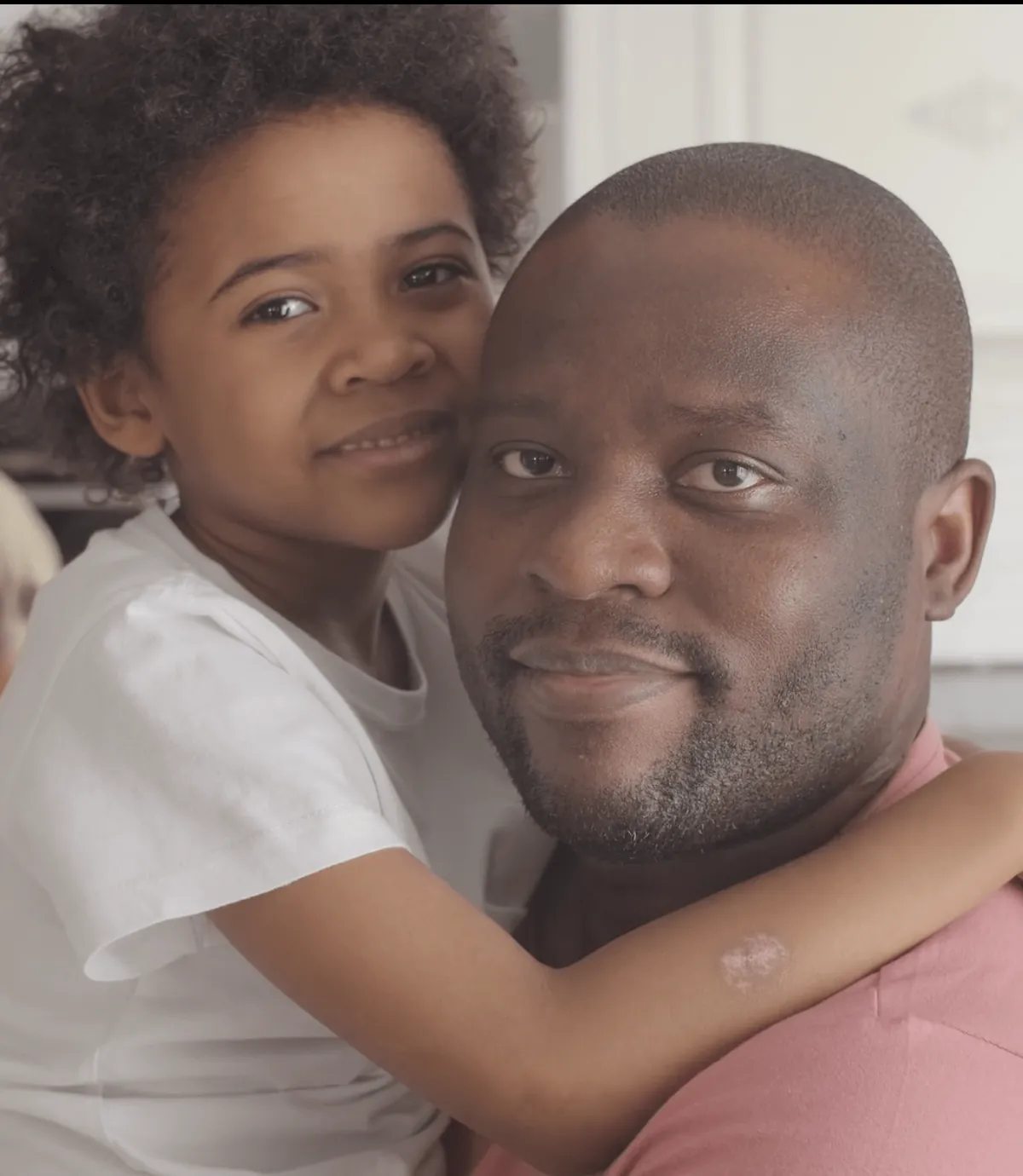 Foster father embracing his young daughter