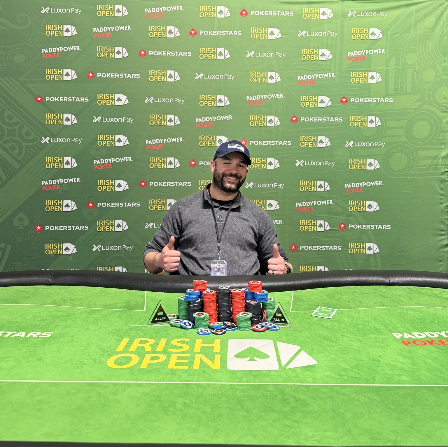 Chris giving two thumbs up beside an Irish Open poker table