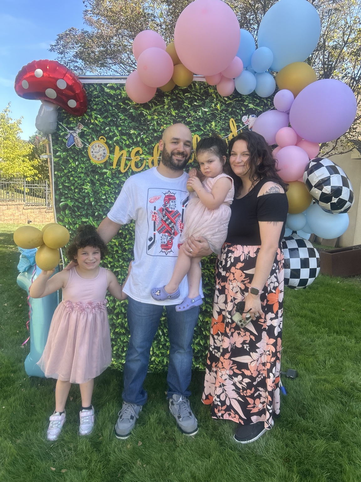 A family portrait in front of pastel balloons